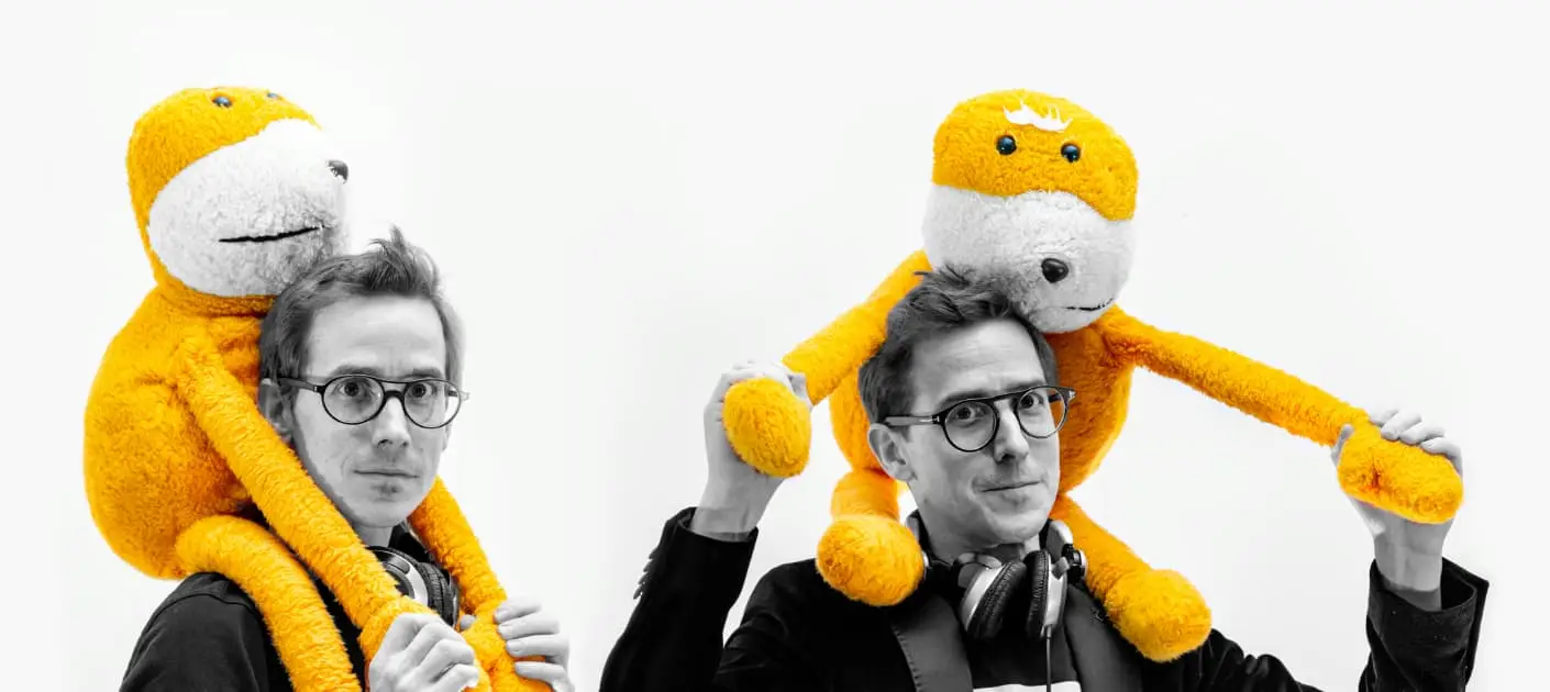 Julien et Jérôme portant chacun une peluche de singe jaune sur les épaules